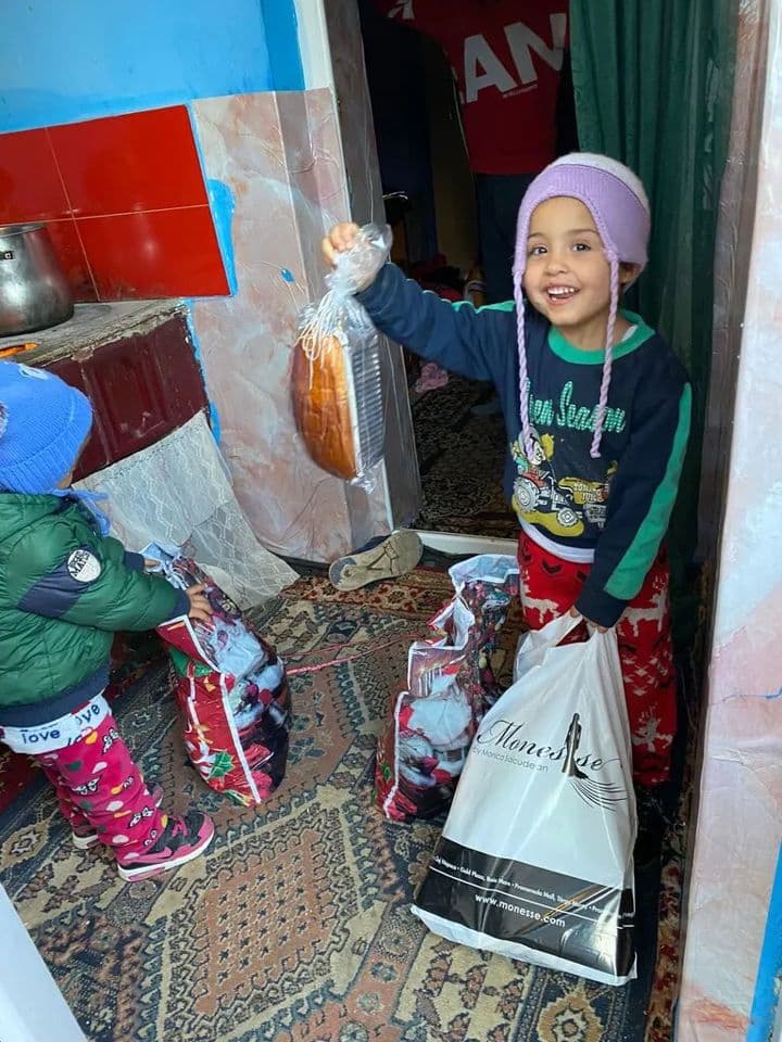Copil bucuros, cu cozonacul și cadourile primite