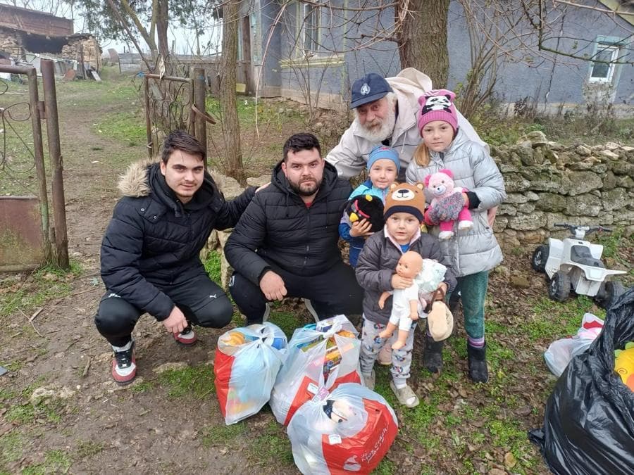 Voluntari alături de o familie cu cadourile primite